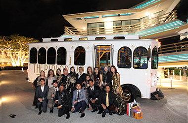 A white vintage-style Parlor Car Trolley at bachelor party transportation service with peoples infront