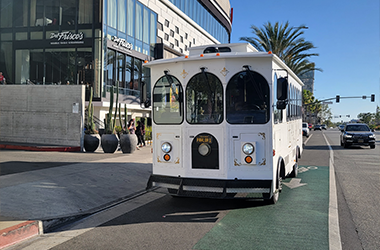 A white vintage-style Parlor Car Trolley on road waiting for premium services