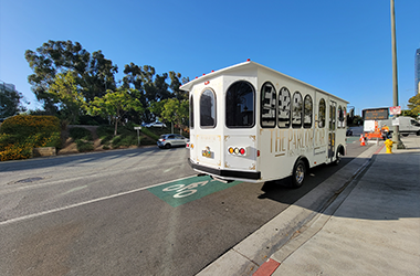 A white vintage-style Parlor Car Trolley on road for prom services